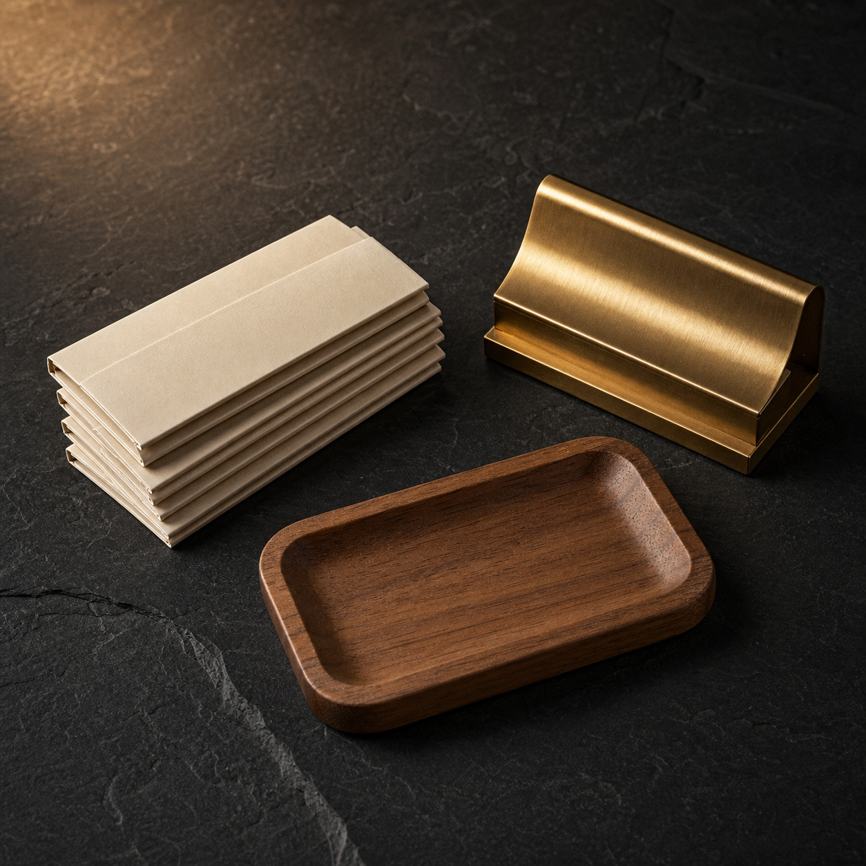 Rolling papers, tray, and brass accessories on slate
