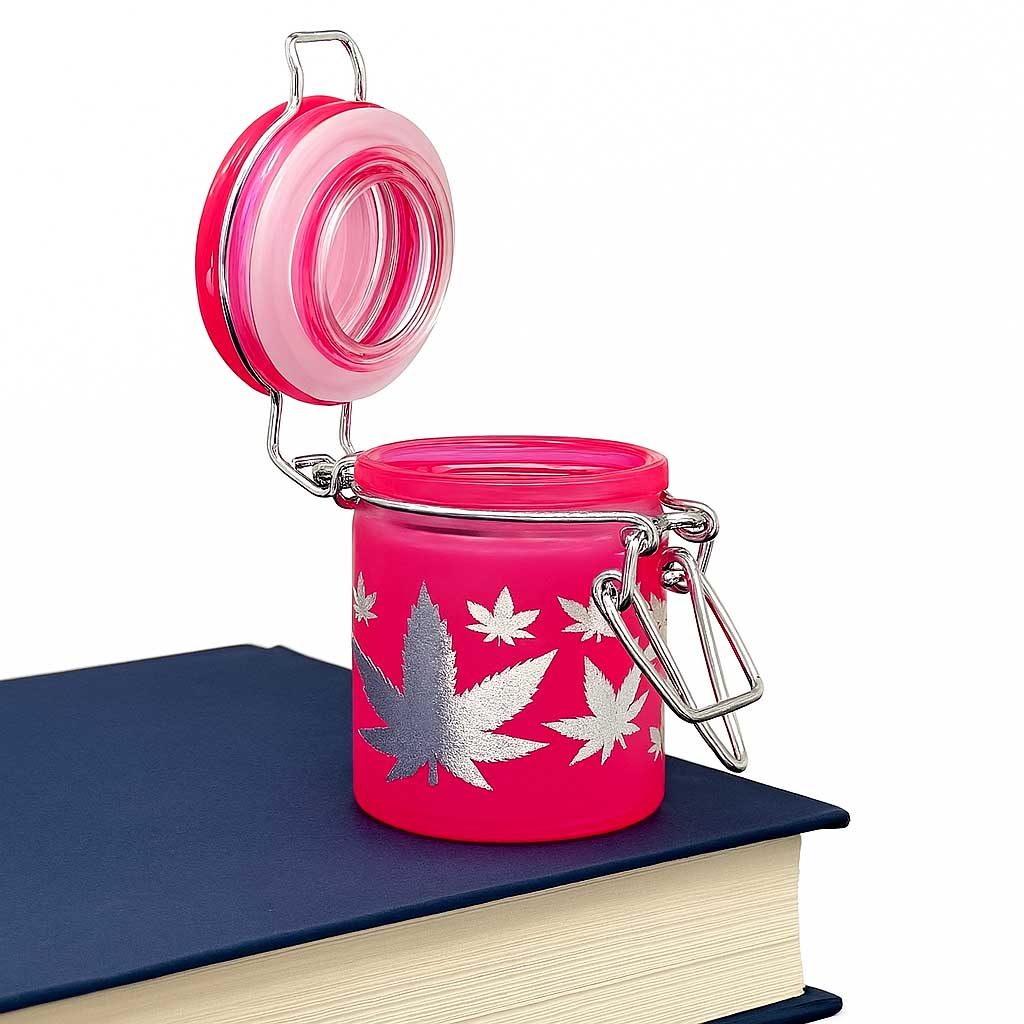 Pink silver-leaves stash jar shown on a book – Online Smoke and Vape